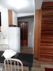 una cucina con frigorifero, tavolo e sedie di Espaço Kayan a Cunha