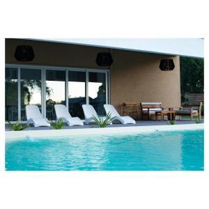 a group of white chairs and a swimming pool at Villa Portezuelo in Junín