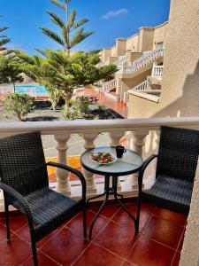 a balcony with two chairs and a table on a porch at Apartament CALETA in Caleta De Fuste