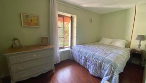 - une chambre avec un lit, une commode et une fenêtre dans l'établissement La nébuleuse, à Notre-Dame-de-lʼIsle