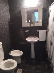 a bathroom with a sink and a toilet and a mirror at Casa Termas in Termas de Río Hondo