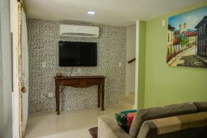 a living room with a flat screen tv on a wall at Bangalô Pipa Resort in Pipa