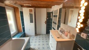 La salle de bains est pourvue d'une baignoire, d'un lavabo et d'une baignoire. dans l'établissement La nébuleuse, à Notre-Dame-de-lʼIsle