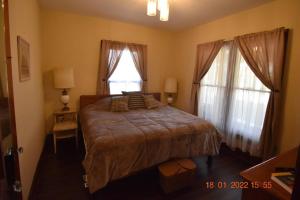 a bedroom with a large bed and two windows at Bungalow in Bloom in French Lick