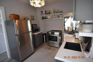 uma cozinha com um frigorífico de aço inoxidável e um fogão em Bungalow in Bloom em French Lick