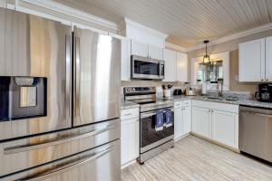 a kitchen with white cabinets and a stainless steel refrigerator at Squirrels Nest in Asheville