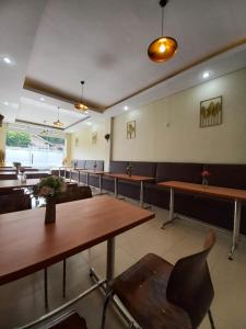 una sala d'attesa con tavoli e sedie e una involontaria di Grand Avira Hotel a Batu Merah