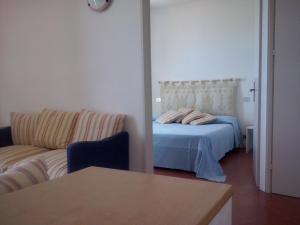 a bedroom with a bed and a couch at Rocca Ruja Vip in Stintino