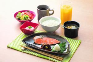 a table with a plate of food and a drink at KEIKYU EX INN Keikyu Kawasaki-Station in Kawasaki