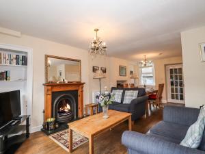 uma sala de estar com lareira e sofá em Becksteps Cottage em Grasmere