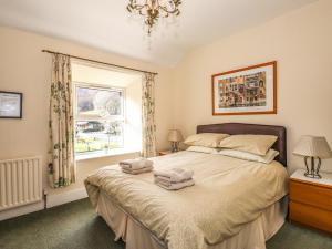 um quarto com uma cama com duas toalhas em Becksteps Cottage em Grasmere