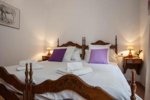 a bedroom with a large bed with purple and white pillows at Maritim Apartments in Valencia