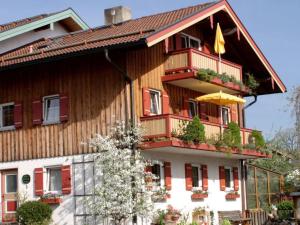 a wooden building with a balcony and an umbrella at Haus Oberland in Bad Endorf