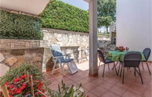 a patio with a table and chairs and a stone wall at 1 Bedroom Gorgeous Apartment In Pavicini in Pavicini