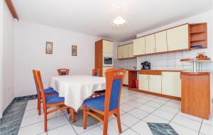 a kitchen and dining room with a table and chairs at 2 Bedroom Cozy Apartment In Grizane in Kostelj