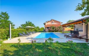 a swimming pool in a yard with chairs and a house at Awesome Home In Pazin With Outdoor Swimming Pool in Pazin