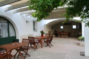 un patio con tavoli e sedie in legno in un edificio di Agroturismo Biniai Nou a Mahón