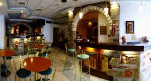 Hotel Diana في كوروني: بار يوجد به كراسي وطاولات في المطعم