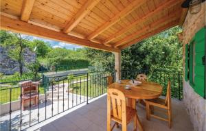 een patio met een houten tafel en stoelen op een balkon bij Beautiful Home In Labin With Kitchen in Labin