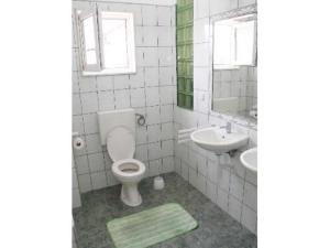 ein Badezimmer mit einem WC, einem Waschbecken und einem Spiegel in der Unterkunft Apartment Miranda in Bol