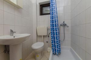 een badkamer met een toilet, een wastafel en een douche bij Apartments Marko in Drage +12 foto's