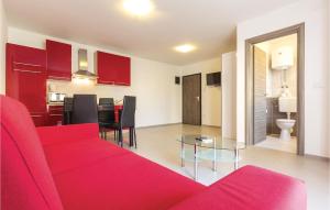 een woonkamer met een rode bank en een tafel bij Awesome Apartment In Premantura With Wifi And Outdoor Swimming Pool in Premantura