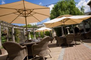a patio area with tables, chairs and umbrellas at Hotel du Vin Cheltenham in Cheltenham