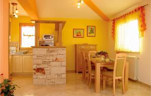 a kitchen and dining room with a table and chairs at Awesome Home In Golubovo With House Sea View in Krnjaloža