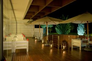 a room with tables and umbrellas on a wooden floor at Finca Prats Hotel Golf & Spa in Lleida