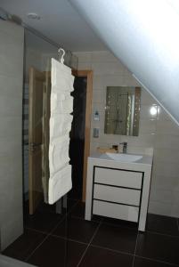 a bathroom with a sink and a mirror and towels at Les Bleuets in Scharrachbergheim Irmstett