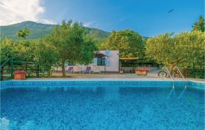 a swimming pool in front of a house with mountains at Nice Home In Vrgorac With Kitchen in Vrgorac