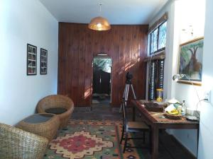 a living room with a table and a wooden wall at Samira's Birds & Butterflies Park-Spashram Ganga Beach Retreat in Rishīkesh