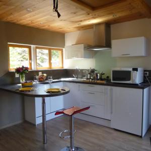 a kitchen with a counter and a table with two wine glasses at Gîte &quot;La Bergerie&quot;- Chalet indépendant in Kirchberg