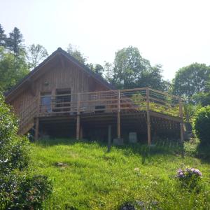 uma grande casa de madeira com um grande deque em Gîte &quot;La Bergerie&quot;- Chalet indépendant em Kirchberg
