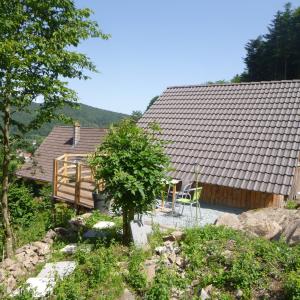 a house with a deck and a table and chairs at Gîte &quot;La Bergerie&quot;- Chalet indépendant in Kirchberg