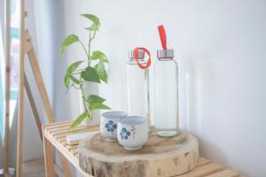 Ấp Thiện Phước的住宿－Ẩn Homestay Mũi Né，木桌上的玻璃瓶和2杯
