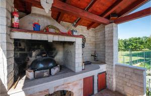 an outdoor kitchen with a large brick fireplace at Nice Home In Marcana With Wifi in Marčana