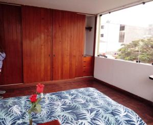 1 dormitorio con cama y ventana grande en Sucesac, en Lima