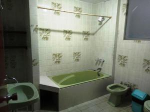 baño con bañera verde y aseo en Sucesac en Lima