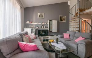 a living room with two gray couches and pink pillows at Gorgeous Home In Labin With Kitchen in Raša