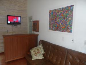 a living room with a couch and a flat screen tv at Pousada e Chalés Itamoara in São Thomé das Letras +47 photos