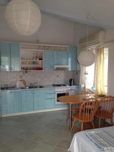 a kitchen with blue cabinets and a table and chairs at Apartments Vanda in Vrboska +16 photos