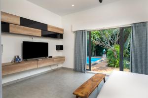a living room with a tv and a couch at The Friendship Villa by Amatak in Siem Reap