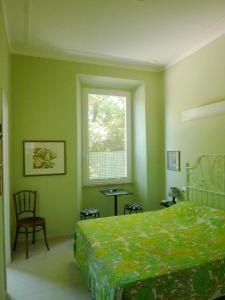 1 dormitorio con cama, ventana y silla en Casa Particular 25Rooms, en Roma