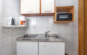 a small kitchen with a sink and a microwave at Amazing Apartment In Crikvenica With Kitchenette in Crikvenica