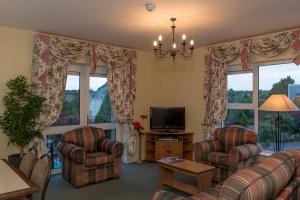 a living room with two chairs and a television at Killarney Self-Catering - Haven Suites in Killarney