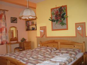 - une chambre avec un grand lit et un miroir dans l'établissement Pensjonat Lotos, à Krynica Morska