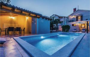 a swimming pool in front of a house at Nice Home In Medulin With 2 Bedrooms, Wifi And Outdoor Swimming Pool in Medulin