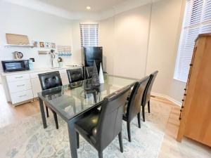 a dining room with a glass table and black chairs at Wrigleyville Friends Unit - 5bdrm in Chicago