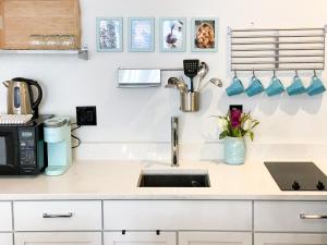 a kitchen counter with a sink and a microwave at Wrigleyville Friends Unit - 5bdrm in Chicago +15 photos